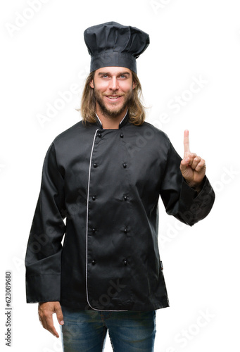 Young handsome cook man with long hair over isolated background showing and pointing up with finger number one while smiling confident and happy.