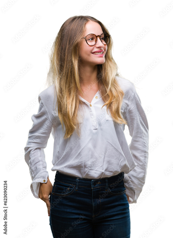 Young beautiful blonde business woman wearing glasses over isolated background looking away to side with smile on face, natural expression. Laughing confident. Young beautiful blonde business woman wearing glasses over isolated background looking away to side with smile on face, natural expression. Laughing confident.