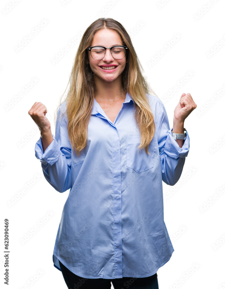 Young beautiful blonde business woman wearing glasses over isolated background excited for success with arms raised celebrating victory smiling. Winner concept. Young beautiful blonde business woman wearing glasses over isolated background excited for success with arms raised celebrating victory smiling. Winner concept.