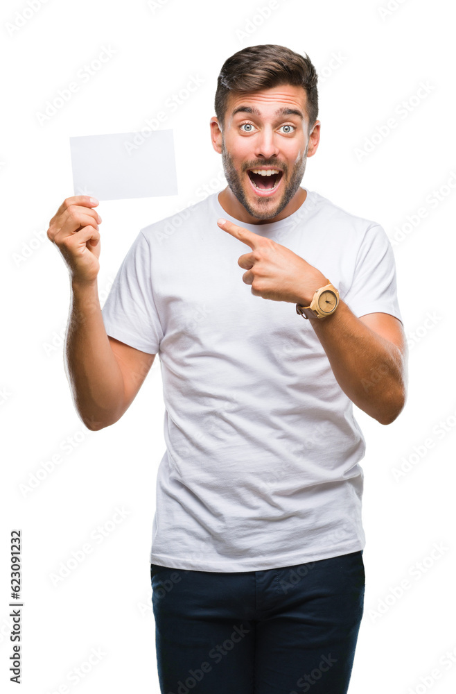 Young handsome man holding blank card over isolated background very happy pointing with hand and finger Young handsome man holding blank card over isolated background very happy pointing with hand and finger