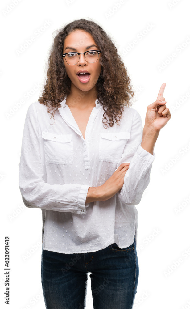 Beautiful young hispanic woman with a big smile on face, pointing with hand and finger to the side looking at the camera. Beautiful young hispanic woman with a big smile on face, pointing with hand and finger to the side looking at the camera.