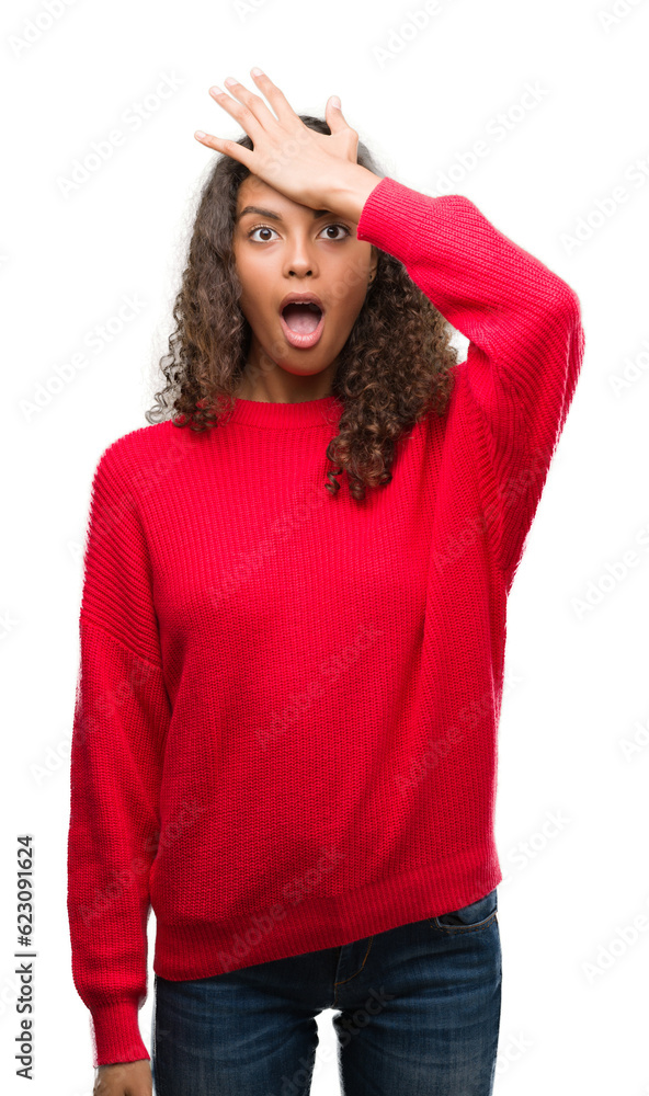 Young hispanic woman wearing red sweater surprised with hand on head for mistake, remember error. Forgot, bad memory concept. Young hispanic woman wearing red sweater surprised with hand on head for mistake, remember error. Forgot, bad memory concept.