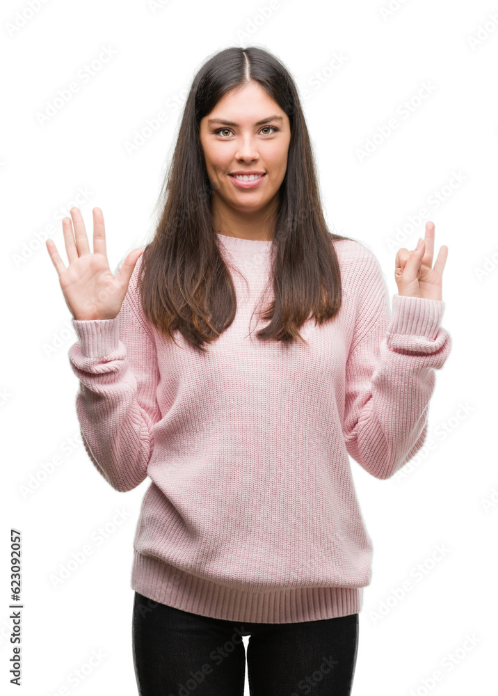 Young beautiful hispanic woman wearing a sweater showing and pointing up with fingers number seven while smiling confident and happy. Young beautiful hispanic woman wearing a sweater showing and pointing up with fingers number seven while smiling confident and happy.