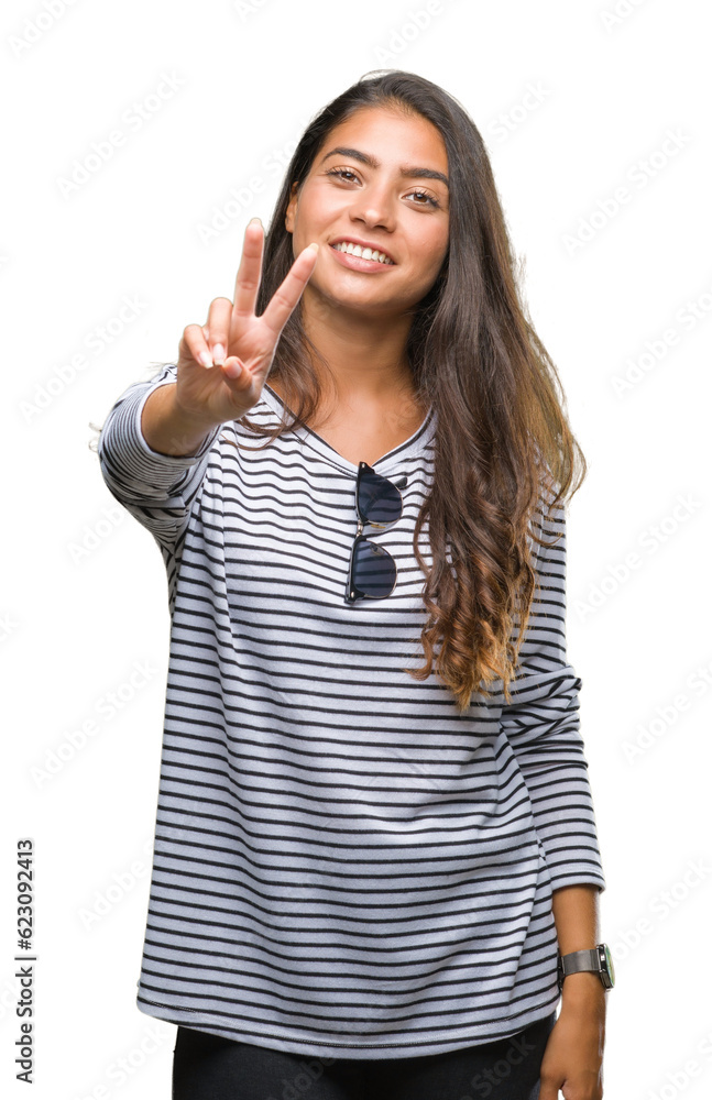 Young beautiful arab woman wearing sunglasses over isolated background smiling looking to the camera showing fingers doing victory sign. Number two. Young beautiful arab woman wearing sunglasses over isolated background smiling looking to the camera showing fingers doing victory sign. Number two.