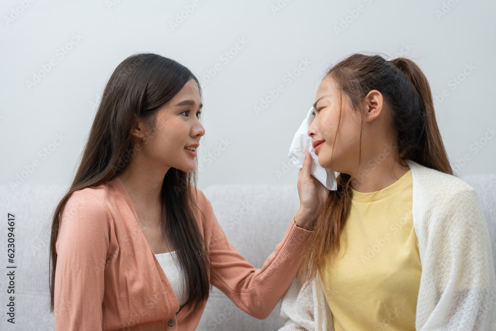 Two women talking about problems at home. Asian women embrace to calm their sad best friends from feeling down. Female friends supporting each other. Problems, friendship, and care concept Two women talking about problems at home. Asian women embrace to calm their sad best friends from feeling down. Female friends supporting each other. Problems, friendship, and care concept