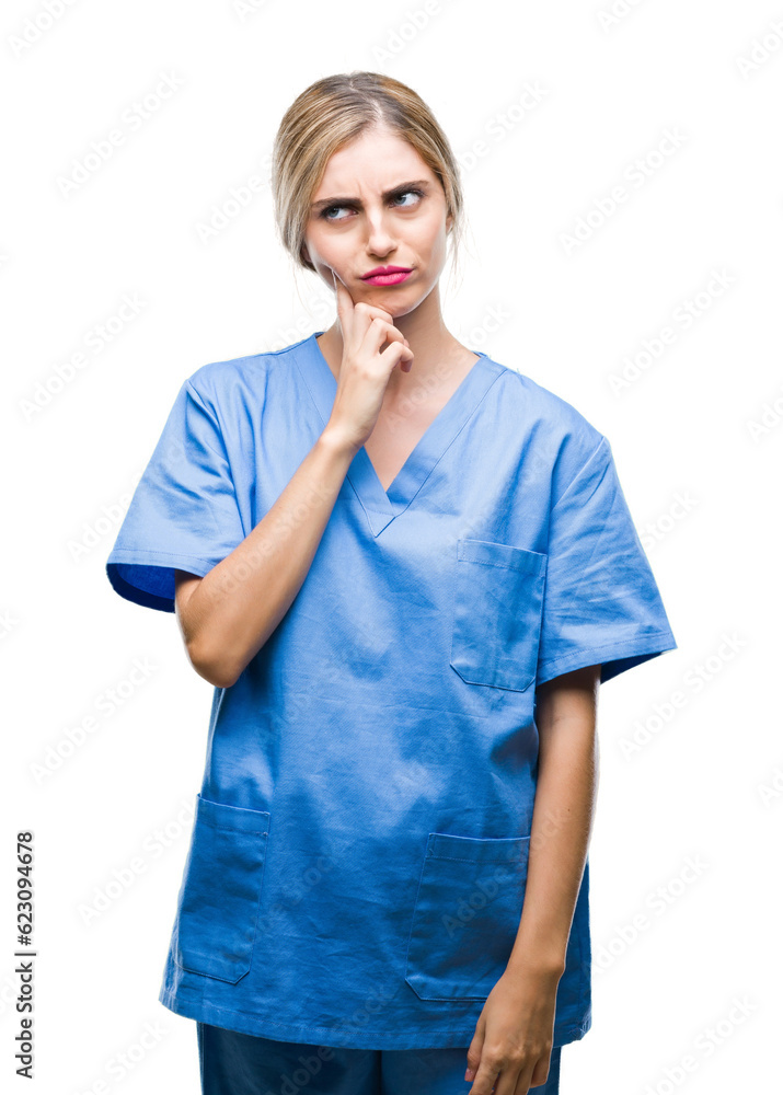 Young beautiful blonde doctor surgeon nurse woman over isolated background with hand on chin thinking about question, pensive expression. Smiling with thoughtful face. Doubt concept. Young beautiful blonde doctor surgeon nurse woman over isolated background with hand on chin thinking about question, pensive expression. Smiling with thoughtful face. Doubt concept.