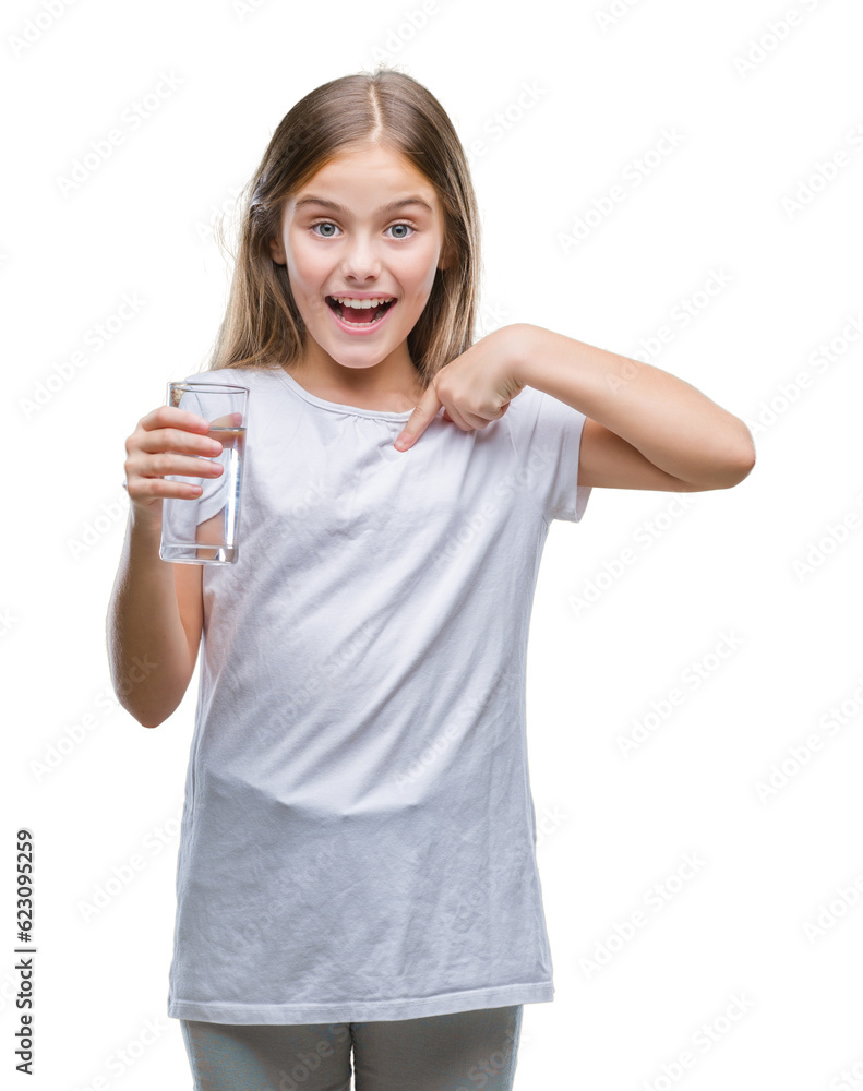 Young beautiful girl drinking glass of water over isolated background with surprise face pointing finger to himself Young beautiful girl drinking glass of water over isolated background with surprise face pointing finger to himself