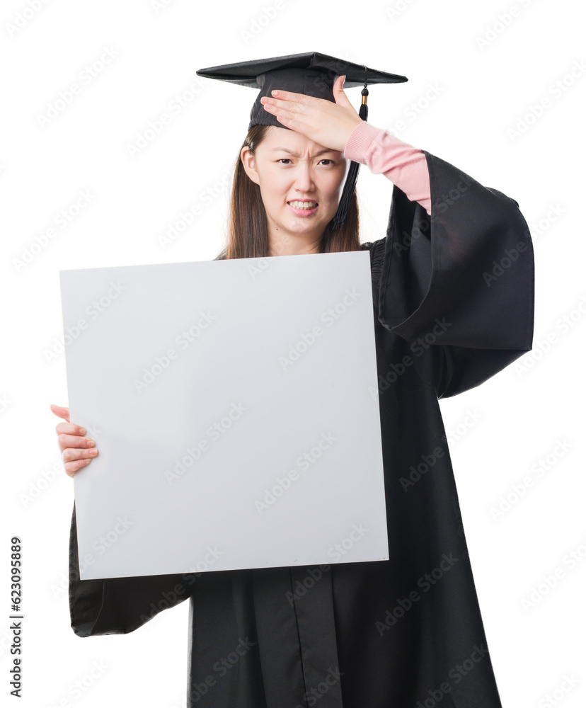 Young Chinese woman wearing graduate uniform holding banner stressed with hand on head, shocked with shame and surprise face, angry and frustrated. Fear and upset for mistake. Young Chinese woman wearing graduate uniform holding banner stressed with hand on head, shocked with shame and surprise face, angry and frustrated. Fear and upset for mistake.