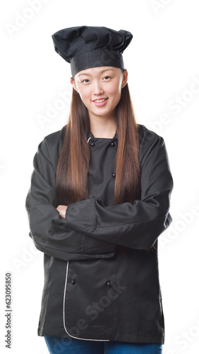 Young Chinese woman over isolated background wearing chef uniform happy face smiling with crossed arms looking at the camera. Positive person.