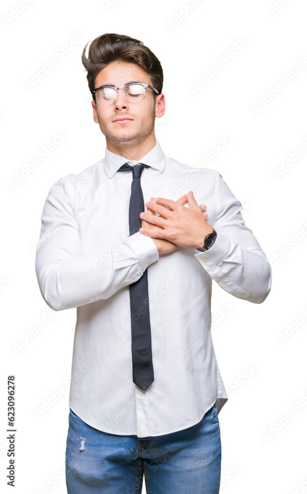 Young business man wearing glasses over isolated background smiling with hands on chest with closed eyes and grateful gesture on face. Health concept. Young business man wearing glasses over isolated background smiling with hands on chest with closed eyes and grateful gesture on face. Health concept.
