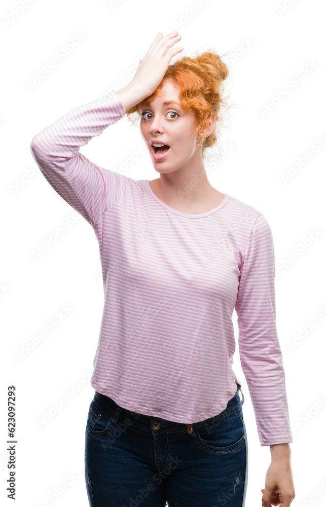 Young redhead woman surprised with hand on head for mistake, remember error. Forgot, bad memory concept.