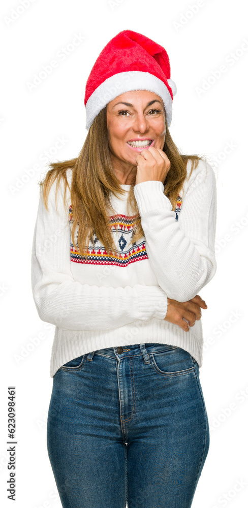 Middle age adult woman wearing winter sweater and chrismat hat over isolated background looking stressed and nervous with hands on mouth biting nails. Anxiety problem. Middle age adult woman wearing winter sweater and chrismat hat over isolated background looking stressed and nervous with hands on mouth biting nails. Anxiety problem.