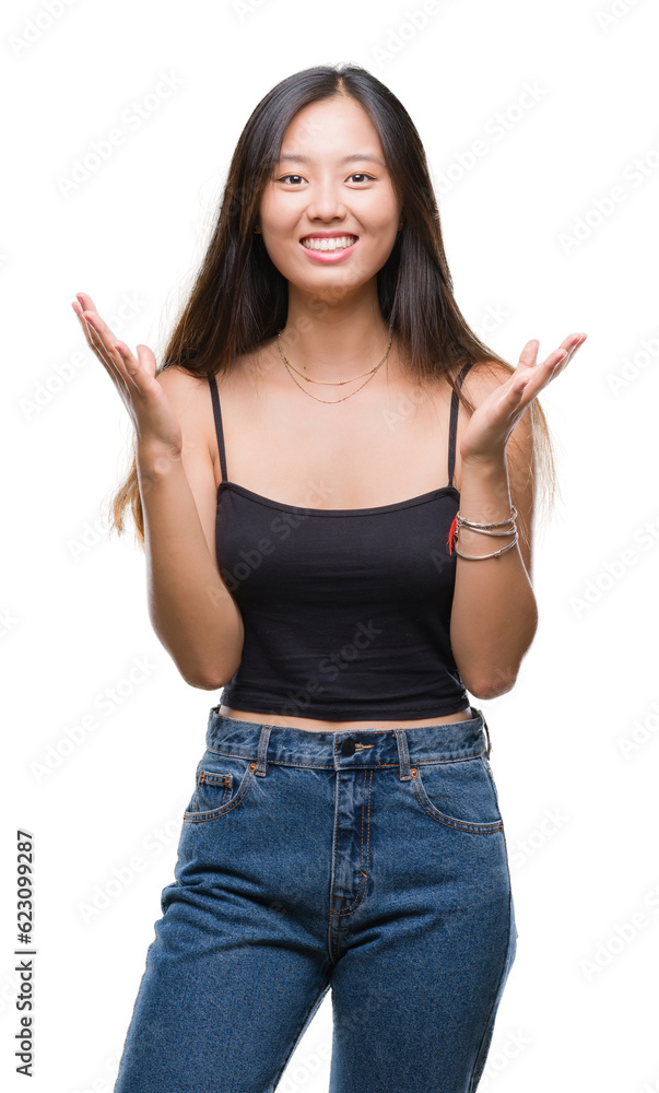 Young asian woman over isolated background celebrating crazy and amazed for success with arms raised and open eyes screaming excited. Winner concept Young asian woman over isolated background celebrating crazy and amazed for success with arms raised and open eyes screaming excited. Winner concept