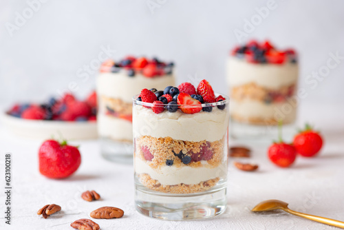 Dessert in a glasses with berries, whipped cream and biscuit. Healthy food, vegan, sugar, gluten and lactose free.