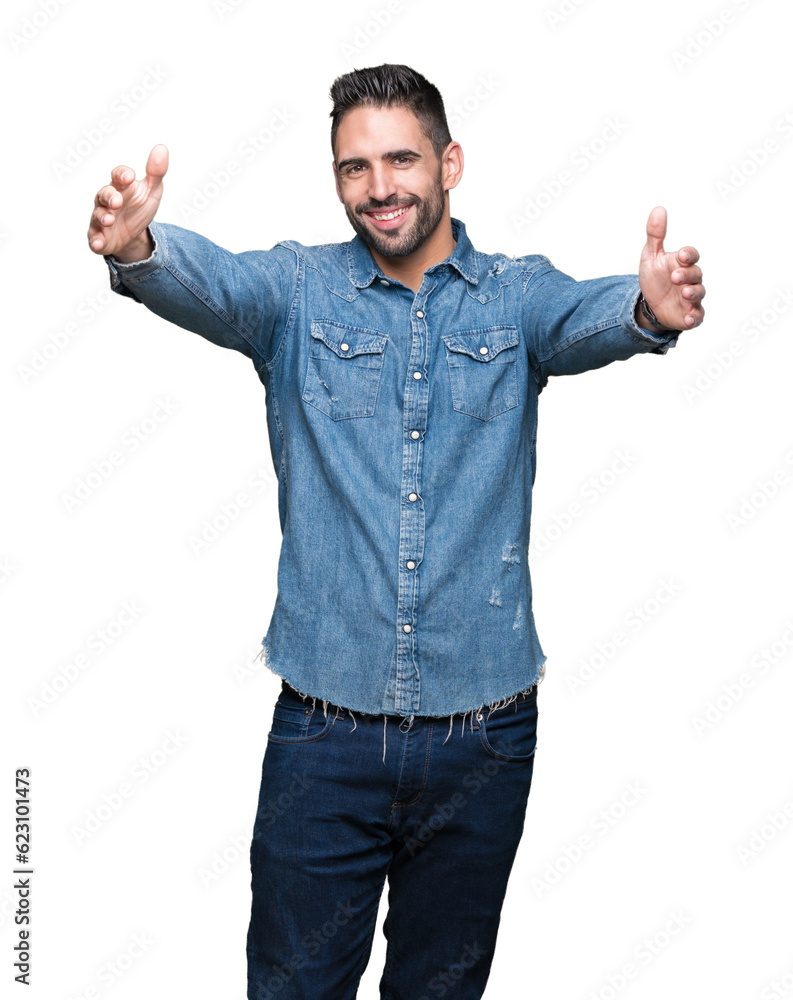 Fototapeta premium Young handsome man over isolated background looking at the camera smiling with open arms for hug. Cheerful expression embracing happiness.