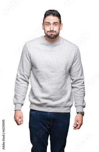 Young handsome man wearing sweatshirt over isolated background puffing cheeks with funny face. Mouth inflated with air, crazy expression.