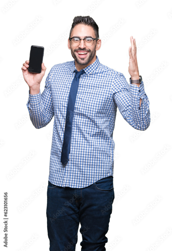 Young business man showing smartphone screen over isolated background very happy and excited, winner expression celebrating victory screaming with big smile and raised hands Young business man showing smartphone screen over isolated background very happy and excited, winner expression celebrating victory screaming with big smile and raised hands