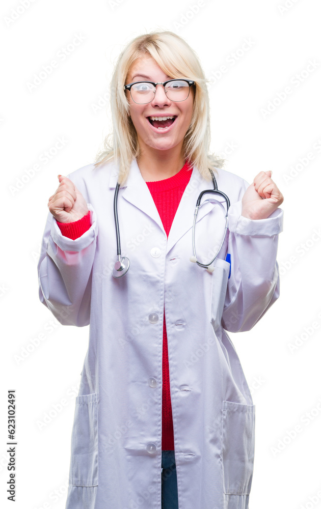 Young beautiful blonde doctor woman wearing medical uniform over isolated background celebrating surprised and amazed for success with arms raised and open eyes. Winner concept. Young beautiful blonde doctor woman wearing medical uniform over isolated background celebrating surprised and amazed for success with arms raised and open eyes. Winner concept.