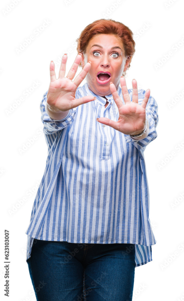 Atrractive senior caucasian redhead woman over isolated background afraid and terrified with fear expression stop gesture with hands, shouting in shock. Panic concept. Atrractive senior caucasian redhead woman over isolated background afraid and terrified with fear expression stop gesture with hands, shouting in shock. Panic concept.
