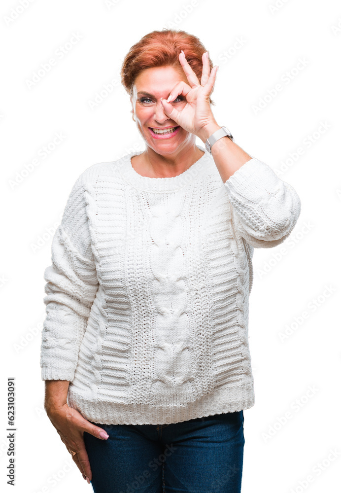 Atrractive senior caucasian redhead woman wearing winter sweater over isolated background doing ok gesture with hand smiling, eye looking through fingers with happy face. Atrractive senior caucasian redhead woman wearing winter sweater over isolated background doing ok gesture with hand smiling, eye looking through fingers with happy face.