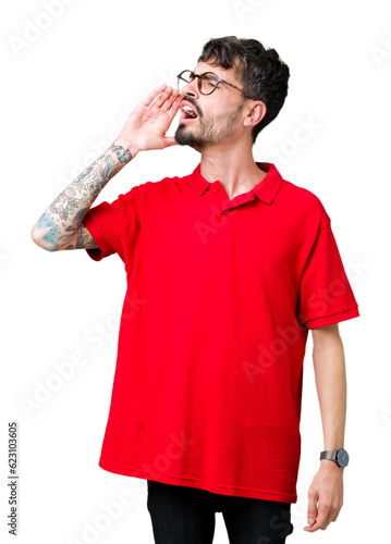 Young handsome man wearing glasses over isolated background shouting and screaming loud to side with hand on mouth. Communication concept.