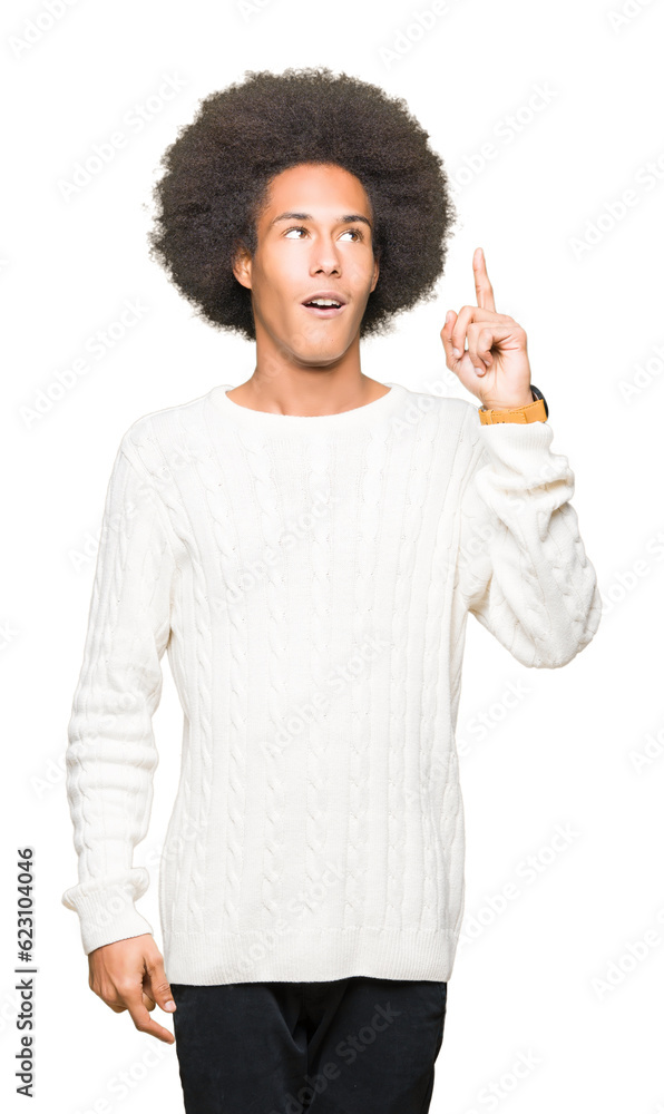 Young african american man with afro hair wearing winter sweater pointing finger up with successful idea. Exited and happy. Number one. Young african american man with afro hair wearing winter sweater pointing finger up with successful idea. Exited and happy. Number one.