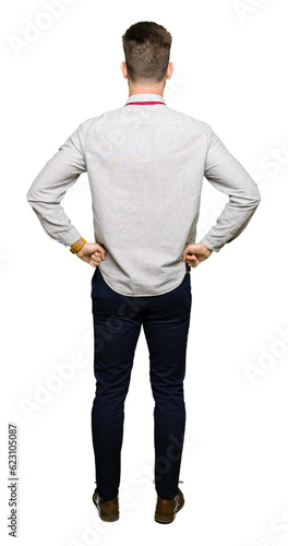 Young handsome business man standing backwards looking away with arms on body