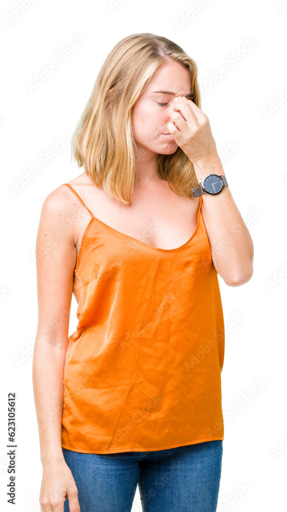 Beautiful young woman wearing orange shirt over isolated background tired rubbing nose and eyes feeling fatigue and headache. Stress and frustration concept. Beautiful young woman wearing orange shirt over isolated background tired rubbing nose and eyes feeling fatigue and headache. Stress and frustration concept.