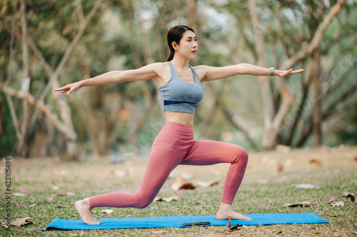 Portrait of young woman practicing yoga in garden.female happiness.  in the park blurred background. Healthy lifestyle and relaxation concept. © Nuttapong punna