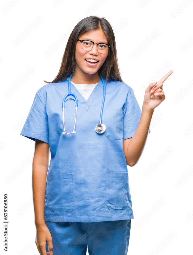 Young asian doctor woman over isolated background with a big smile on face, pointing with hand and finger to the side looking at the camera. Young asian doctor woman over isolated background with a big smile on face, pointing with hand and finger to the side looking at the camera.