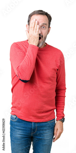 Handsome middle age hoary senior man wearing winter sweater over isolated background covering one eye with hand with confident smile on face and surprise emotion.