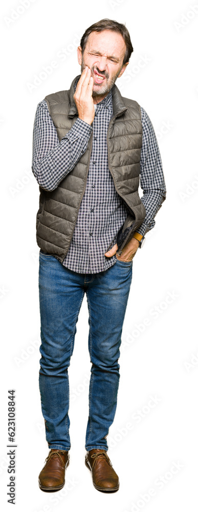 Middle age handsome man wearing winter vest touching mouth with hand with painful expression because of toothache or dental illness on teeth. Dentist concept. Middle age handsome man wearing winter vest touching mouth with hand with painful expression because of toothache or dental illness on teeth. Dentist concept.
