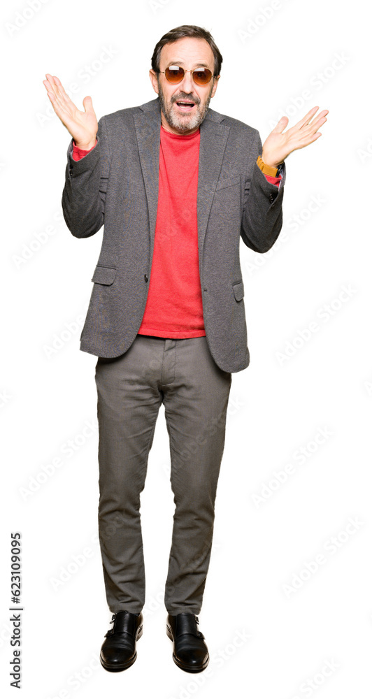 Middle age handsome business man wearing sunglasses clueless and confused expression with arms and hands raised. Doubt concept. Middle age handsome business man wearing sunglasses clueless and confused expression with arms and hands raised. Doubt concept.