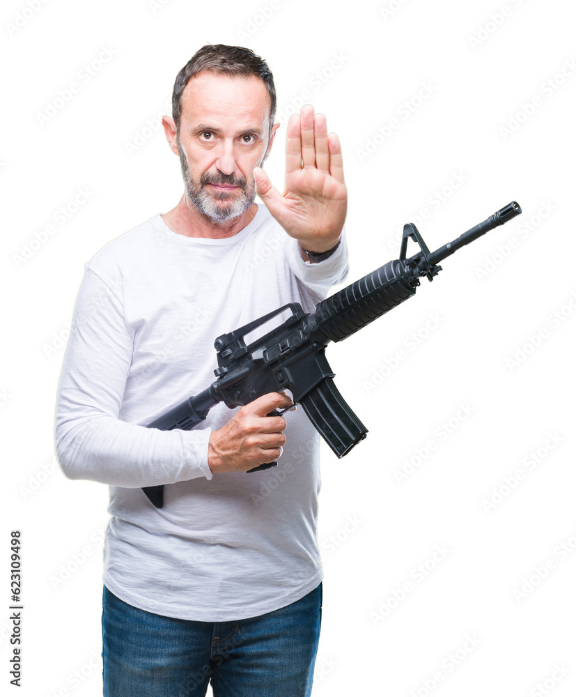 Middle age senior hoary criminal man holding gun weapon over isolated background with open hand doing stop sign with serious and confident expression, defense gesture Middle age senior hoary criminal man holding gun weapon over isolated background with open hand doing stop sign with serious and confident expression, defense gesture