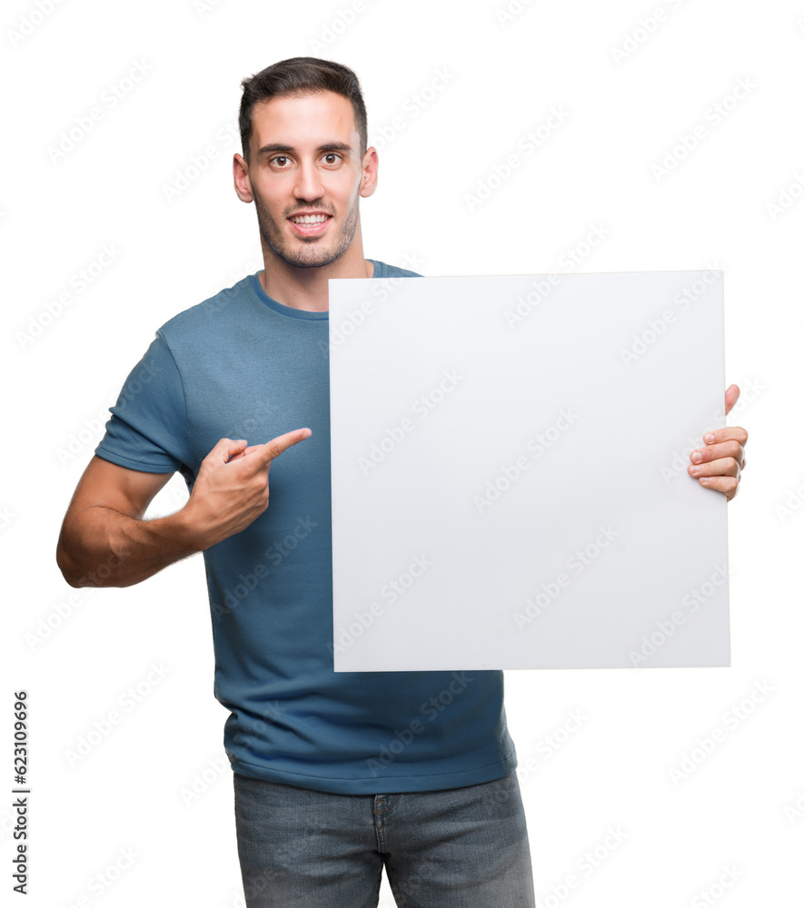 Handsome young man holding advertising banner very happy pointing with hand and finger Handsome young man holding advertising banner very happy pointing with hand and finger