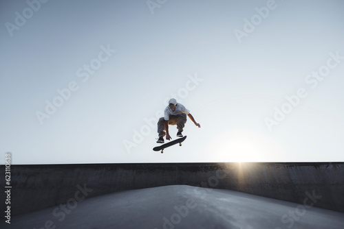 Foto Skater doing kickflip on the ramp at skate park - Stylish skaterboy training out