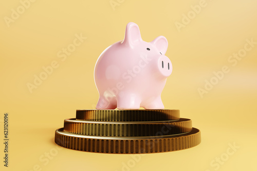 Fotografie Pink piggy bank on a stack of gold coins on yellow background