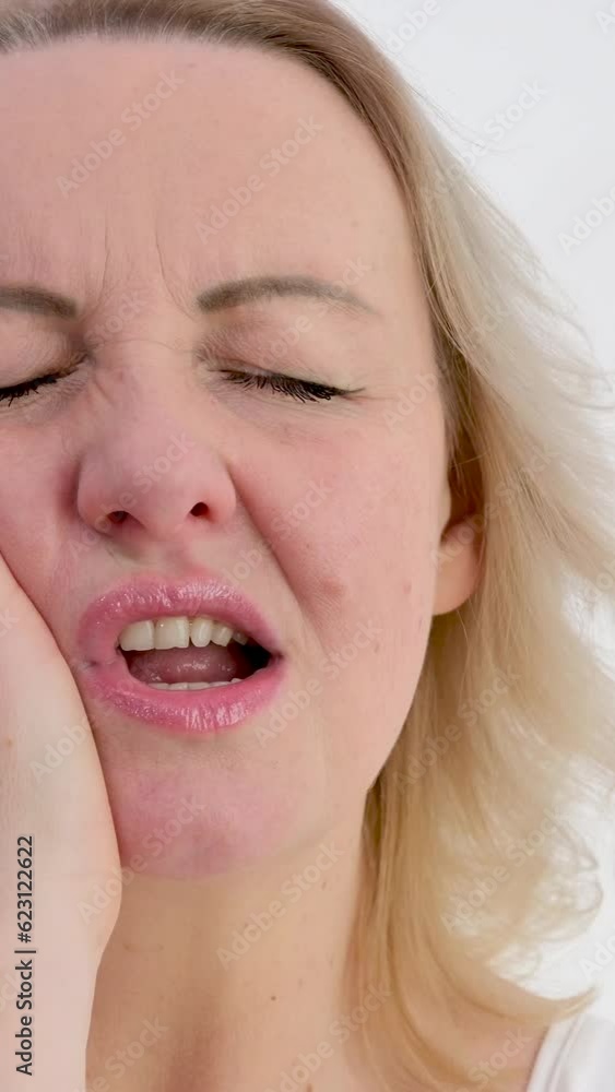 vertical video. unbearable toothache woman closed her eyes put hand to her left cheek place for text going to the doctor do not delay dental treatment vertical video. unbearable toothache woman closed her eyes put hand to her left cheek place for text going to the doctor do not delay dental treatment