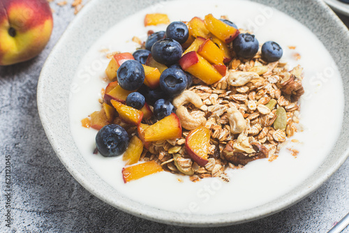Granola with yogurt, peach, blueberries in a plate 