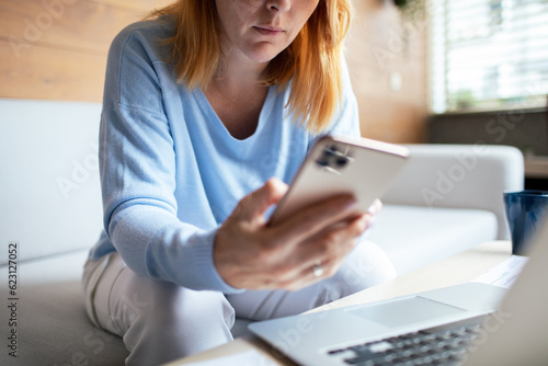 Mid adult woman using a smart phone at home