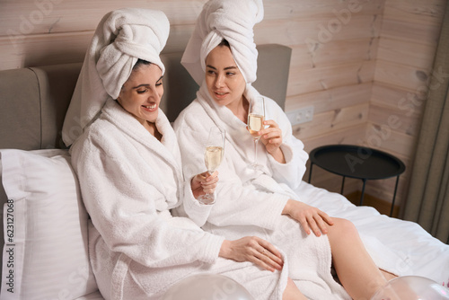 Pretty women drinking champagne in luxury apartment during bachelorette party