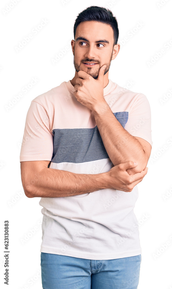 Young handsome man wearing casual clothes with hand on chin thinking about question, pensive expression. smiling with thoughtful face. doubt concept. Young handsome man wearing casual clothes with hand on chin thinking about question, pensive expression. smiling with thoughtful face. doubt concept.