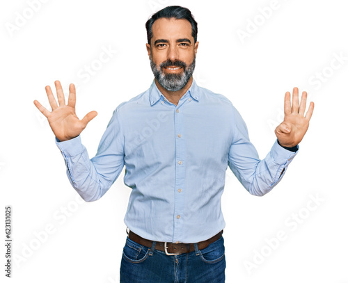 Middle aged man with beard wearing business shirt showing and pointing up with fingers number nine while smiling confident and happy.