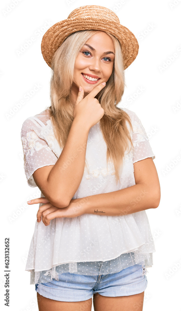 Young blonde girl wearing summer hat looking confident at the camera smiling with crossed arms and hand raised on chin. thinking positive. Young blonde girl wearing summer hat looking confident at the camera smiling with crossed arms and hand raised on chin. thinking positive.
