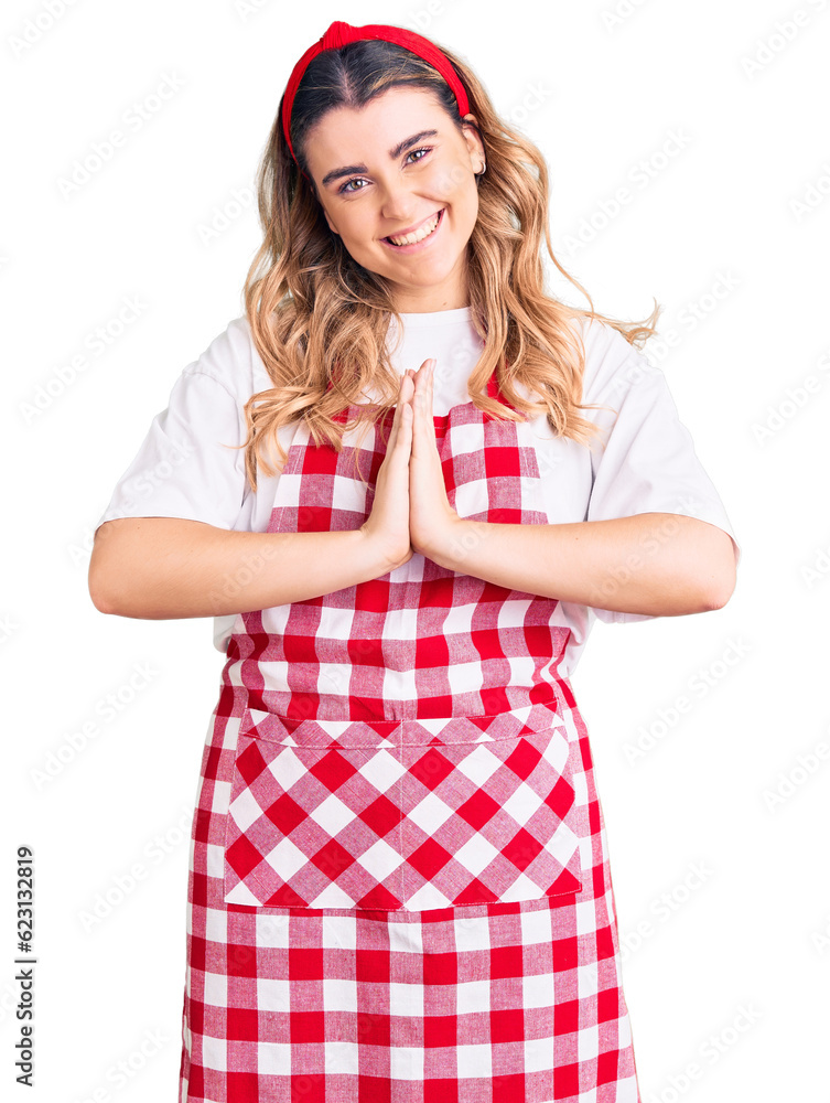 Young caucasian woman wearing apron praying with hands together asking for forgiveness smiling confident. Young caucasian woman wearing apron praying with hands together asking for forgiveness smiling confident.