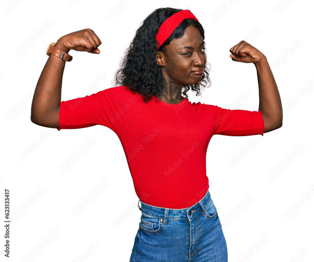 Beautiful african young woman wearing casual clothes showing arms muscles smiling proud. fitness concept. Beautiful african young woman wearing casual clothes showing arms muscles smiling proud. fitness concept.