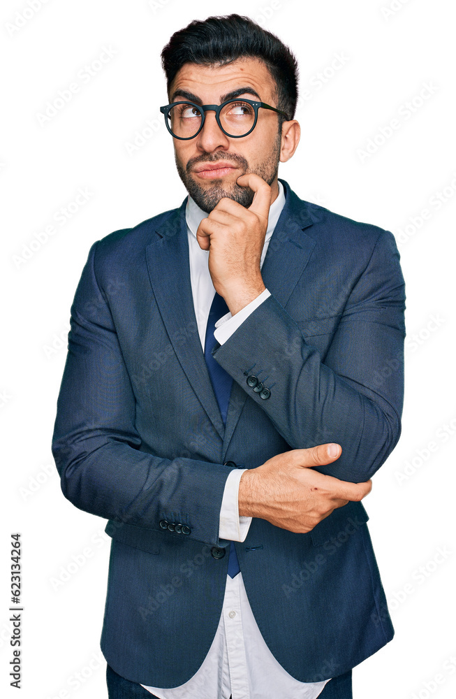 Hispanic man with beard wearing business suit and tie serious face thinking about question with hand on chin, thoughtful about confusing idea Hispanic man with beard wearing business suit and tie serious face thinking about question with hand on chin, thoughtful about confusing idea