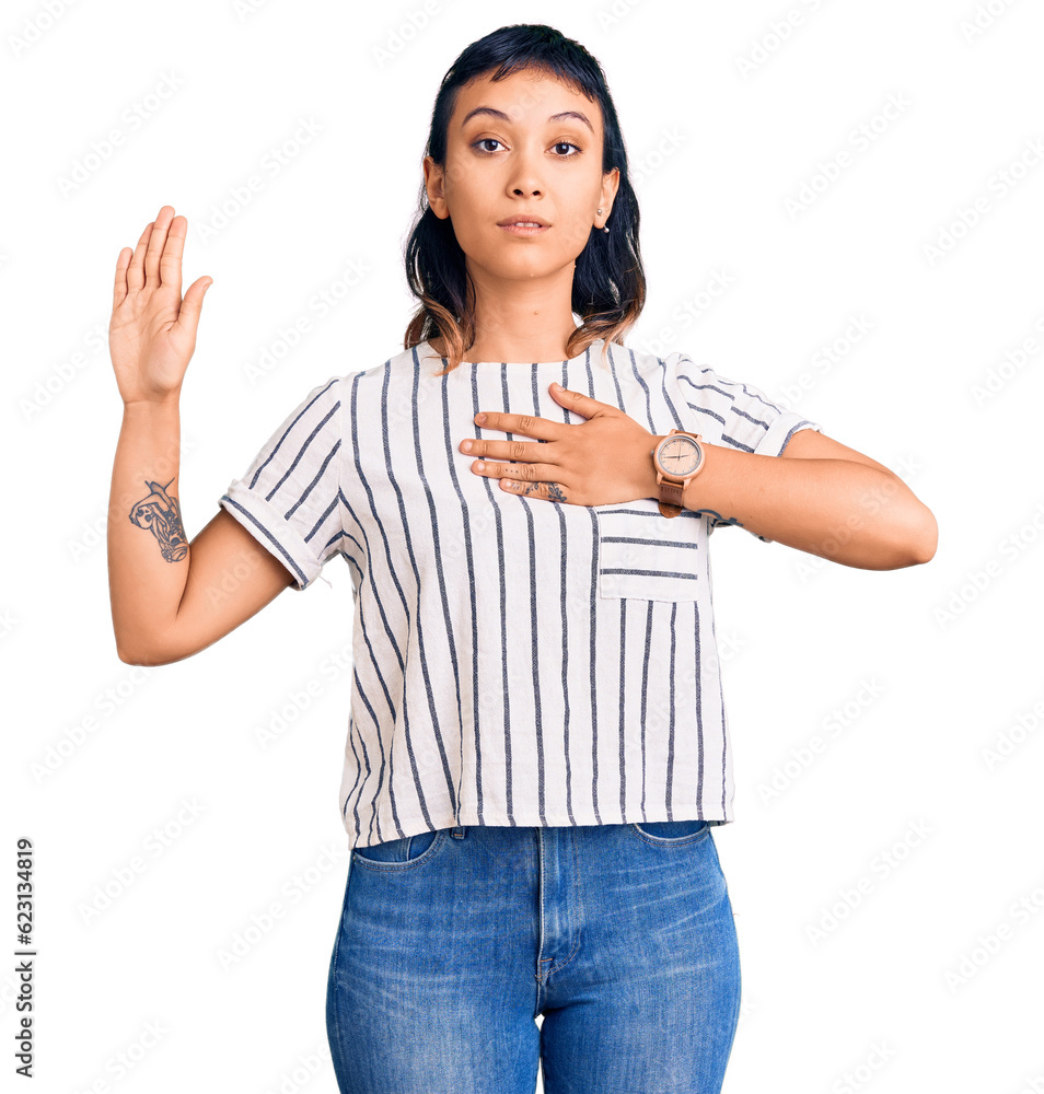 Young woman wearing casual clothes swearing with hand on chest and open palm, making a loyalty promise oath Young woman wearing casual clothes swearing with hand on chest and open palm, making a loyalty promise oath