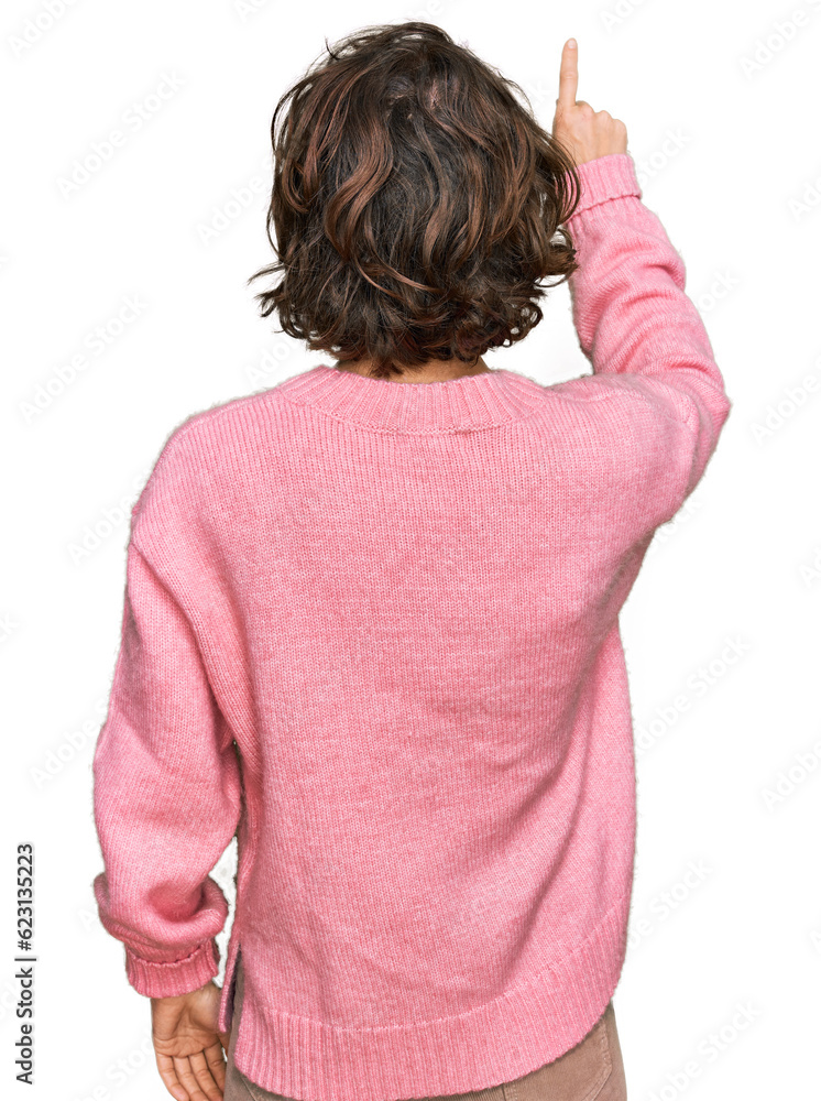 Young hispanic woman wearing casual clothes posing backwards pointing ahead with finger hand Young hispanic woman wearing casual clothes posing backwards pointing ahead with finger hand