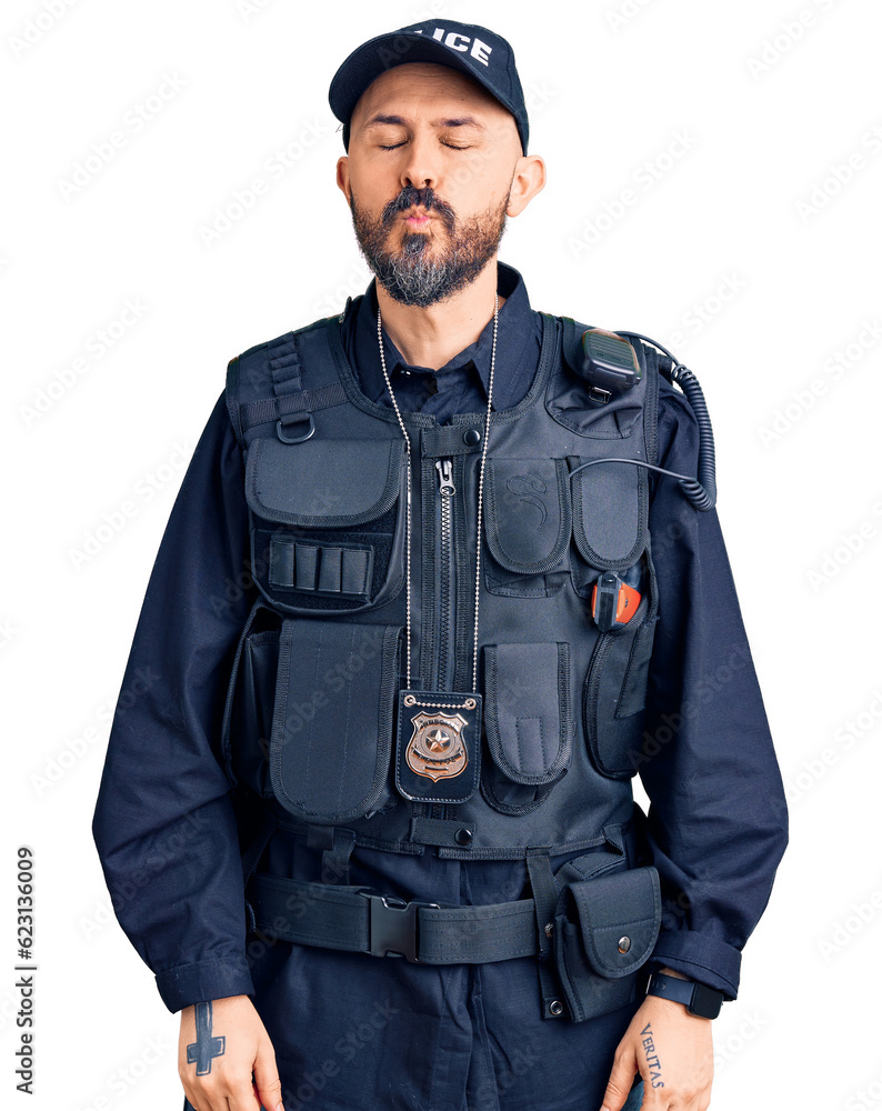 Young handsome man wearing police uniform looking at the camera blowing a kiss on air being lovely and sexy. love expression. Young handsome man wearing police uniform looking at the camera blowing a kiss on air being lovely and sexy. love expression.